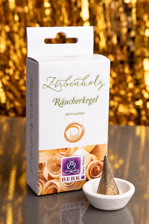 Räucherkegel Zirbenholz mit Kegel im Keramikhalter vor goldenem Hintergrund